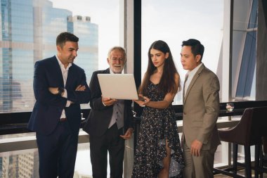 Kafkas iş adamları ayakta duruyor ve bilgisayar laptopuyla iş görüşmesi yapıyorlar.