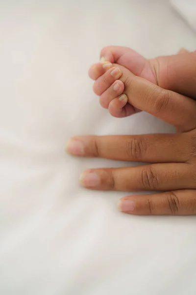 Bebek Eli Annenin Parmağını Beyaz Yatakta Tutuyor — Stok fotoğraf