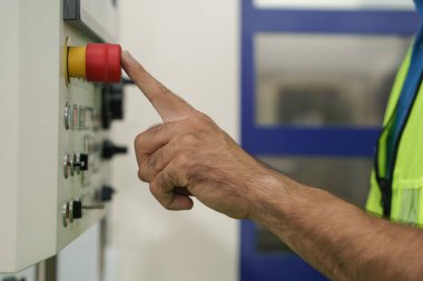 Fabrikadaki cnc makine kontrol panelindeki kırmızı düğmeye bas