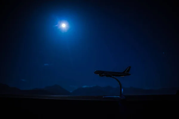 Airplane model on the background of the night skyline in the city. Almaty.