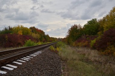 Sonbaharda tren yolu yakınlarında bulutlu bir öğleden sonra