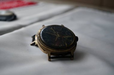 Kırık altın Sovyet saati masanın üzerinde.