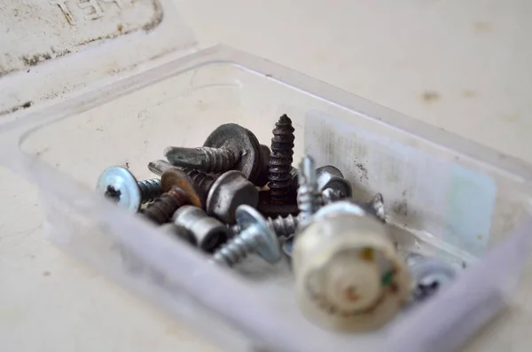 Transparent plastic box with various screws — Stock Photo, Image