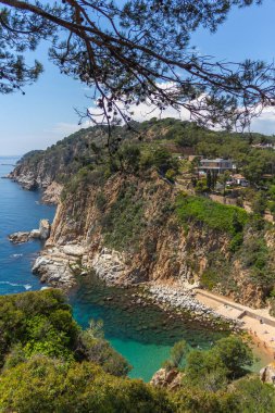 İspanya, Costa Brava 'daki kayalıklarla çevrili kristal berrak plaj