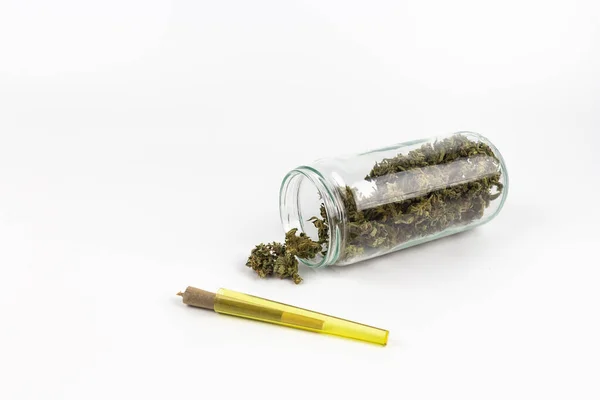 マリファナの芽が入ったガラス瓶と黄色のプラスチックチューブの中の関節 — ストック写真