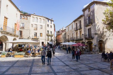 GİRONA, İSPAN - 11 EKİM 2020: Koruyucu maskeli insanlar Besalu kasabasının merkezinde yürüyorlar