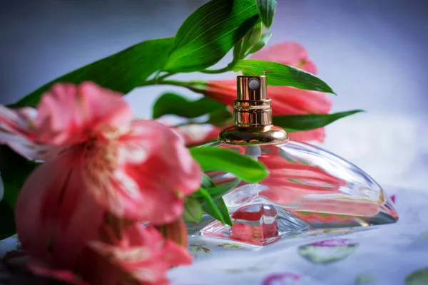 Çiçekli Mavi Zemin Üzerine Parfüm Şişesi — Stok fotoğraf