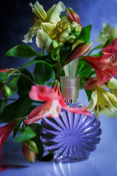 Botella Perfume Con Flores Sobre Fondo Azul —  Fotos de Stock