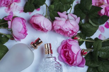 İki şişe parfüm beyaz zemin üzerine çiçekli