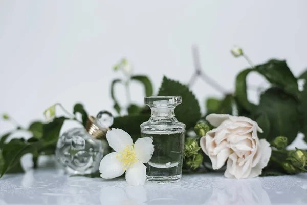 Dwa Małą Butelkę Perfum Białe Wiosenne Kwiaty — Zdjęcie stockowe