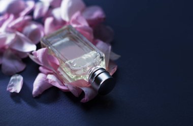 pembe çiçek ve yaprakları ile parfüm şişesi.