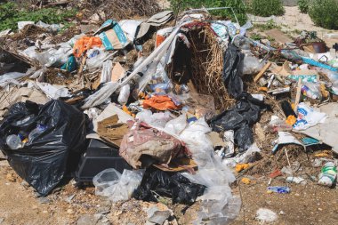 Çöp. Büyük yığın ıvır zıvır ve doğa veya kötü koku ile çevre kirletici şehir parkında terk çöp