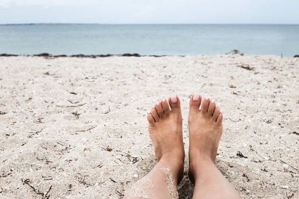 Female feet on sandy ocean beach. Vacation on the beach legs on seashore