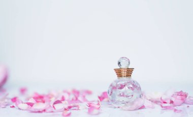 Beyaz arka plan üzerinde pembe çiçekli küçük parfüm 