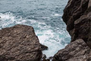 Süt su arasında sahilde büyük kayalar. Yaz günü