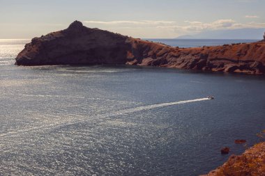 Adriyatik Denizi kıyısında üzerinde bulutlu gökyüzü ile gelen güneş ışınları görüntülemek 