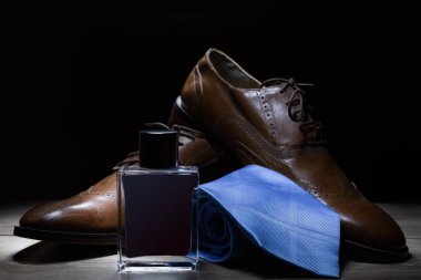 Erkek kahverengi ayakkabı ile kravat ve parfüm 