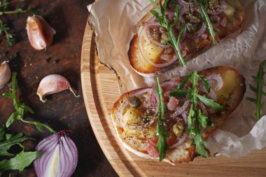 Doğranmış soğan, balık, kapari ve balsamik sirke ile İtalyan bruschetta.