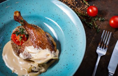 Kızarmış ördek bacak buğday ve mavi plaka üzerinde mantar ile