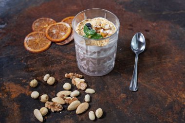 Sağlıklı tatlı yoğurt, fındık ve granola cam mavi kahverengi zemin ahşap kesme tahtası