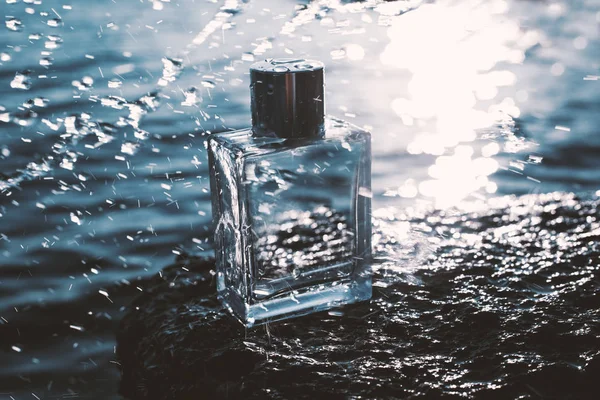Perfume bottle in sea foam at the waters edge