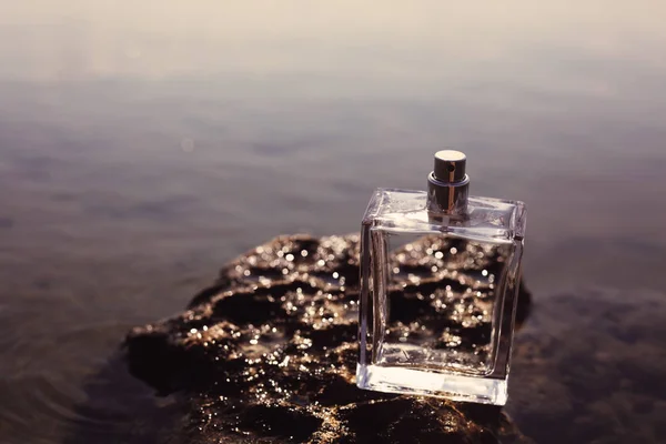 Parfüm Auf Einem Stein Vor Dem Hintergrund Des Wassers — Stockfoto