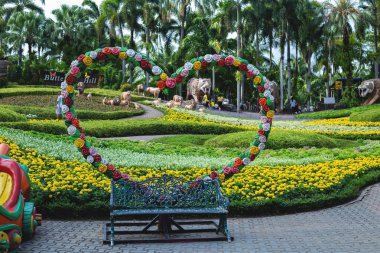 Çiçekli PLA dolu yaz bahçesinde üç kişilik ahşap tezgah