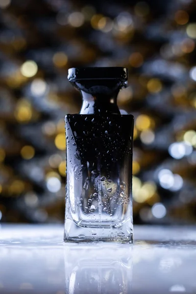Perfume negro sobre fondo bokeh —  Fotos de Stock