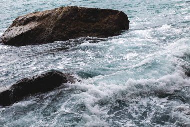 Sahildeki kayalara vuran deniz dalgalarının havadan görünüşü. 