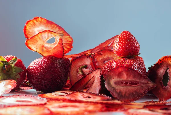 Bagas frescas e batatas fritas de morango em um fundo azul — Fotografia de Stock