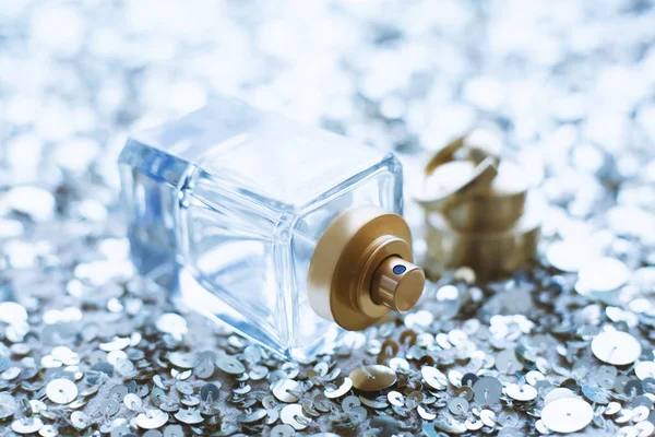 Perfumy na tle cekinów srebrnych — Zdjęcie stockowe