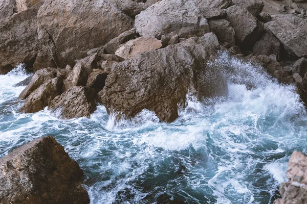 Vista superior das ondas do mar que batem na costa rochosa — Fotografia de Stock