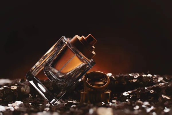 Vrouwelijke fles parfum op donkere achtergrond — Stockfoto