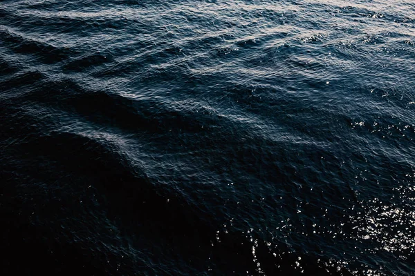 Dark blue waves on a blue body of water outdoors