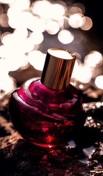 Red female perfume on golden bokeh background — Stock Photo, Image