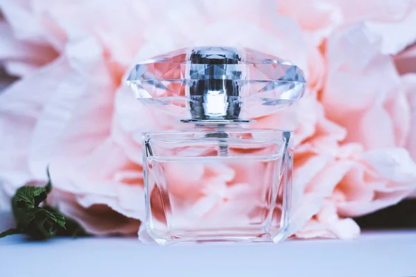 Weibliche Flasche Parfüm mit rosa Blüten — Stockfoto