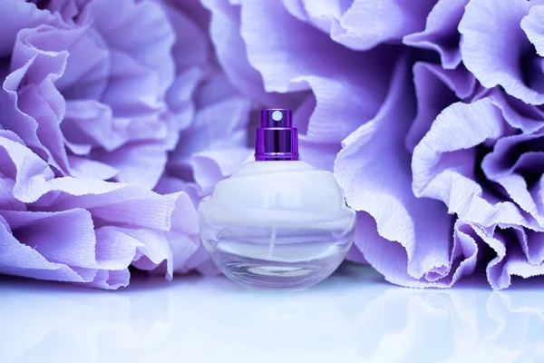 Weibliches Parfüm auf lila Blumen Hintergrund — Stockfoto