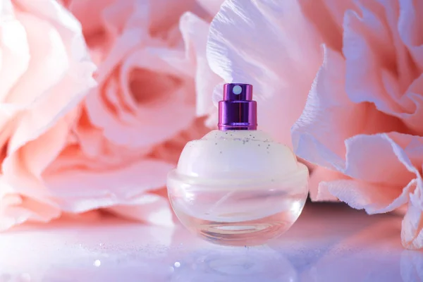 Weibliches Parfüm mit rosa Blüten — Stockfoto