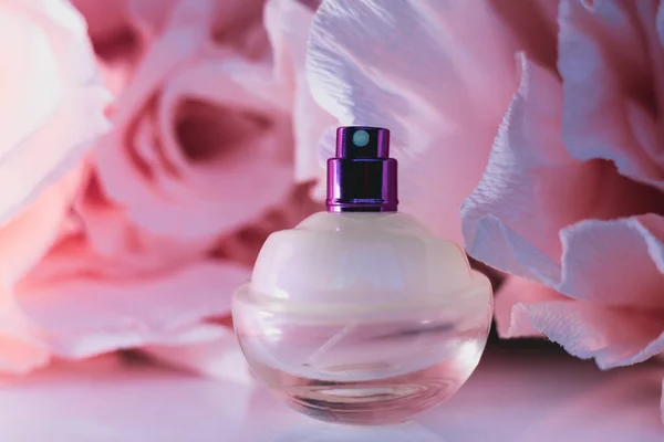 Pembe gül arka plan üzerinde kadın parfüm — Stok fotoğraf
