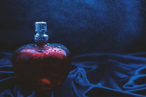 mavi arkaplanda kırmızı parfüm