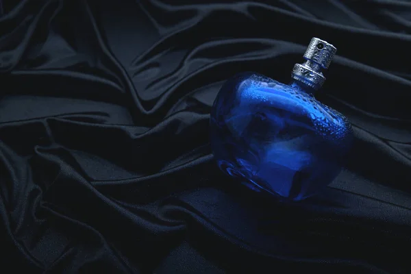 黑色面料上的蓝色香水 — 图库照片