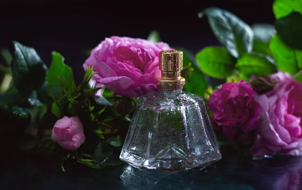 Renkli Arka Planda Çiçekler Olan Bir Şişe Parfüm — Stok fotoğraf