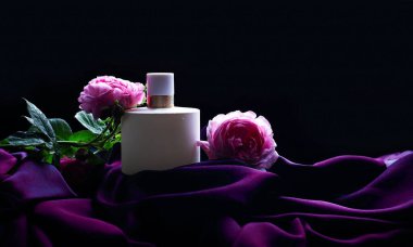 Koyu arkaplanda çiçekler olan parfüm 