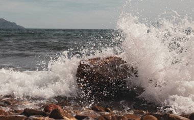 Sahildeki taşlara dalga sıçraması. Akdeniz kıyılarının dalgaları