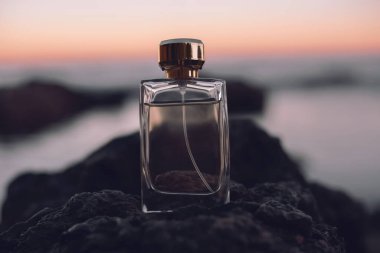 Deniz arka planında parfüm şişesi 