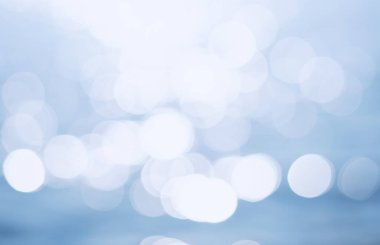 Hassas mavi desenli Bokeh deniz arka planı. Güneşli bir günde, suyun üzerinde bulanık mavi Bokeh parıltısı. dinlenme ve seyahat