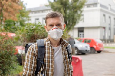 Dışarıdaki koruyucu maskeli genç adam.