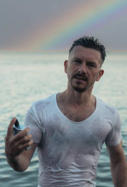 Yakışıklı bir adam ve okyanusa karşı parfüm