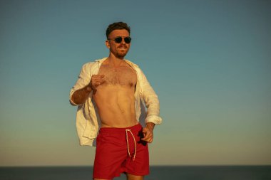 Genç adam denize karşı eğleniyor.