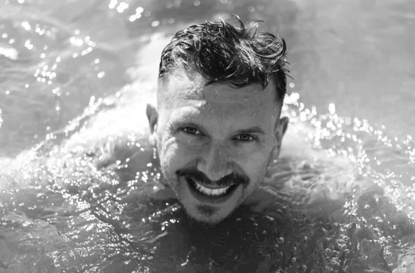 Denizde yüzen mutlu bir adamın portresi.